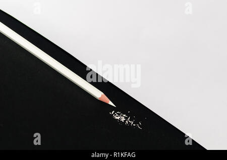 Weiß Bleistift mit Rasieren auf schwarzem Hintergrund isoliert. Makro Fotografie. Ansicht von oben und triange schwarzen und weißen Hintergrund. Stockfoto
