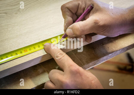 Lineal und Bleistift auf einem hölzernen Hintergrund. Kennzeichnung auf dem Teil. Carpenter's Werkstatt. Arbeit Tischler. Close-up. Stockfoto