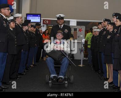 SEATTLE, Washington (Okt. 2010) 15, 2018) Chief Aviation Ordnanceman Juan Nevarez, zugeordnet zu den Marinestützpunkt Kitsap, Escorts ein Vietnam Krieg Veteran durch Side Boys nach der Landung von einem Ehre Flug zum Internationalen Flughafen SeaTac. Service Mitglieder, die ehrenamtlich in der Puget Sound Ehre Flug willkommen zu Hause Zeremonien mehrmals im Jahr zu beteiligen. Puget Sound Ehre Flug ist eine gemeinnützige Organisation, die lokalen Veteranen auf eine alle Unkosten gezahlte Reise zu Tour Memorials in Washington, D.C. Stockfoto