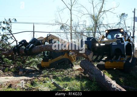 Staff Sgt. Alex Spano, elektrische Facharbeiter und Senior Airman Gonard Caudill, Heavy Equipment operator, sowohl aus der 202. Geben Sie der Camp Blanding, Fla., Tag-Team schweren Baum Ausbau in einer Nachbarschaft innerhalb der 10 Mile Road Bereich von Panama City 16. Okt., 2018. Der 202 wurde für ihr Know-how in der effizienten Route clearing genannt nach dem Hurrikan Michael durch kamen. Stockfoto