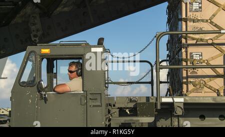 Eine 821St Contingency Response Group Logistik Spezialist von Travis Air Force Base, Calif., leert Ladung von einem Nord-carolina Air National Guard C-17 Globemaster III Tyndall AFB, Fla., Okt. 15, 2018. Nach dem Hurrikan Michaels Verwüstung und innerhalb von 12 Stunden nach Anmeldung, diese Mobilität Flieger flog nach Tyndall, wo Sie re-initiierte Air Traffic für große Cargo Aircraft, die Lieferung von Ausrüstung für die Wiederherstellung Bemühungen an der Basisstation. Stockfoto