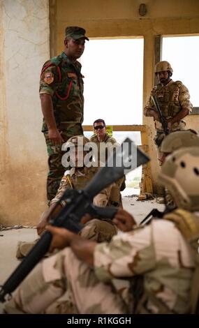 Combined Joint Task Force - inhärenten Neu lösen der Australischen Armee Sgt. Joe Densley und einem irakischen Ausbilder von Bagdad und in der Bekämpfung der Schule beaufsichtigen irakische Soldaten vom 1.BATAILLON, 41st Brigade, da sie Verluste während Cordon und strike Training im Camp Taji, Irak, Okt. 14, 2018 simulieren. Seit Jan. Koalition Personal 2015 haben mehr als 150.000 irakische Soldaten und Frauen quer durch alle Reihen, darunter 55.000 irakische Armee Mitglieder beaufsichtigt; fast 25.000 Polizei- und rund 72.000 Sicherheit, Grenzschutz und Terrorismusbekämpfung Personal. Stockfoto