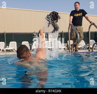 Us-Armee SPC. Tyler R. Richardson, eine Intelligenz Analytiker zu Unternehmen D zugeordnet, 150 Techniker Bataillon, 155 gepanzerte Brigade Combat Team, Mississippi Army National Guard, führt einen Test schwimmen als Teil der Bundeswehr Abzeichen für militärische Kenntnisse Wettbewerb im Camp Arifjan, Kuwait, 15. Oktober 2018. Stockfoto