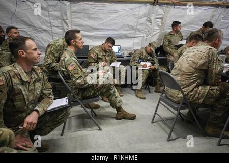 Regimental personal Offiziere und Mitglieder des 2D-Cavalry Regiment Führung komplette Mission Analyse für übung Dragoon bereit, die bei der gemeinsamen multinationalen Readiness Center in Hohenfels, Deutschland, Okt. 18, 2018. Oberst Thomas M. Hough, Commander, 2 CR, vorausgesetzt, die Beratung in der Entwicklung seiner Mitarbeiter besser für den nächsten Schritt der militärischen Entscheidungsfindung vorzubereiten. Dragoon bereit ist, bei der 7th Army Training Command/JMRC LED-Übung, die Bereitschaft zu verbessern und 2CR in Unified Land Betrieb qualifizieren. Stockfoto