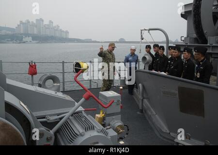 BUSAN, Republik Korea (16. Oktober 2018) Elektroniker 2. Klasse Zachary Braun, aus Tucson, Arizona, Schriftsatz der Republik Korea marine Segler auf dem Anker auf dem Vorschiff des Bluträchers-Klasse meine Gegenmaßnahmen Schiff USS Chief (MCM 14) bei einem Rundgang durch das Schiff. Chief, Teil der Mine Countermeasure Squadron 7, ist die in der indopazifischen Region Interoperabilität mit Partnern zu verbessern und dienen als eine fertige Antwort Plattform für Blindbewerbungen. Stockfoto