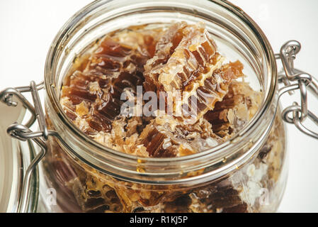 Stücke von Bienenwaben in eine Schüssel geben. Frische Biene Honig in honeycomb Stücke auf weißem Hintergrund. Stockfoto
