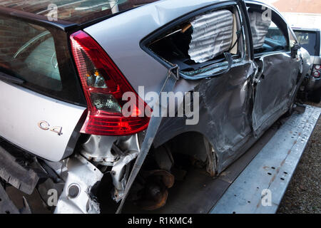 Drei Viertel Rückansicht abgeschrieben Absturz beschädigt Citroen C4 Auto auf eine Erholung des Anhängers Stockfoto