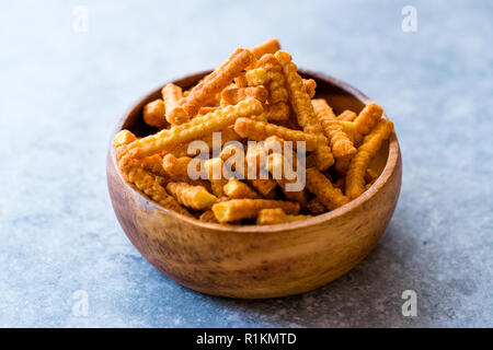 Orange Käse aromatisiert Corn Snacks in Stick Form/Geröstete Chips oder salzigen Cracker in Houten. Organische gebratene Snacks. Stockfoto