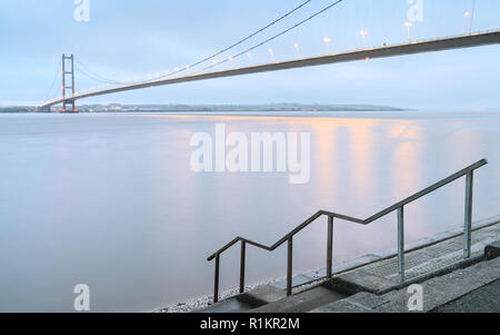 Humber Bridge über der Mündung als Morgendämmerung bricht bei Flut im Herbst, Yorkshire, Großbritannien. Morgen im Herbst, Yorkshire, Großbritannien. Stockfoto