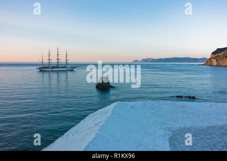 Big Rock und Segeln Schiff bei Sonnenuntergang vor der City Hafen, Insel Skopelos in Griechenland Stockfoto