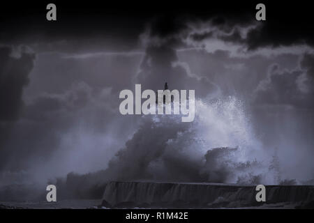 Grossen Sturm wave gegen Leuchtturm von Ave River Mouth bei Sonnenuntergang, Vila do Conde, nördlich von Portugal. Erweiterte Himmel. Farben Blau. Stockfoto