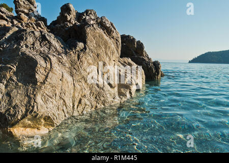 Meer Felsen am kristallklaren türkisfarbenen Wasser am Morgen, Kastani Mamma Mia Strand, Insel Skopelos, Griechenland Stockfoto