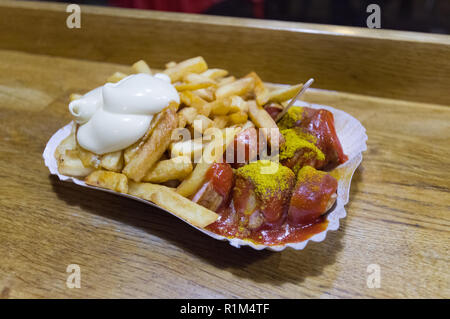 Die Berliner Currywurst, bestehend aus gedämpft und dann gebratene Würstchen in Scheiben geschnitten, gewürzt mit Curry Ketchup und Pommes Frites Stockfoto