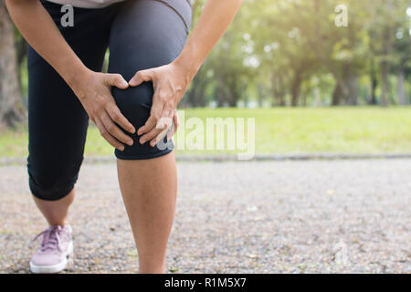 Frau übung und Knieverletzung, sportwoman Leiden und Schmerzen der Muskulatur während des Trainings in Park Stockfoto