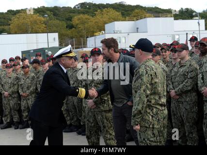 Groton, Anschl. (23. 20, 2018) Vizepräsident. Adm. Charles "Chas" Richard, Commander, Submarine Kräfte begrüßt Gerard Butler, Hauptdarsteller in der kommenden Film "Hunter Killer", zu dem 2017 Battenberg Cup Preisverleihung an der Naval Submarine Base New London. Butler war bei der Zeremonie die Crew der Los-Angeles-Klasse schnell gratulieren - Angriffs-U-Boot USS Hartford (SSN768) auf genannt werden den besten Rund-um-Schiff im Atlantik Flotte und eine Tour des U-Bootes vor einer Vorauszahlung Screening des Films an der Basis Theater später am Nachmittag. Stockfoto