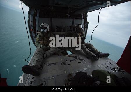 ESMERALDAS, Ecuador (Okt. 2010) 20, 2018) - Senior Chief Naval Aircrewman (Hubschrauber) Scott Chun, von Honolulu (links) und Hospital Corpsman 2. Klasse Alexis valenzuela, aus San Diego, fliegen in einem MH-60S Seahawk, zu der "Ritter" der Hubschrauber Meer Combat Squadron (HSC) 22 zugeordnet. USNS Comfort (T-AH20) ist auf einer 11-Woche medizinische Unterstützung Mission in Zentral- und Südamerika als Teil des US Southern Command's Enduring Promise Initiative. Arbeiten mit Gesundheit und Regierung Partner in Ecuador, Peru, Kolumbien und Honduras, die EINGESCHIFFTEN medizinisches Team kümmert sich an Bord und an Land-basierte Medica Stockfoto