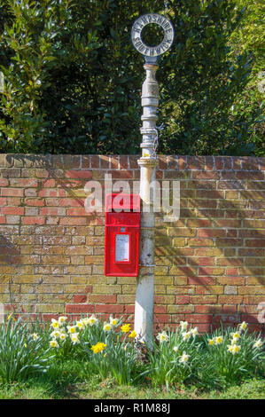 Ländliche postbox auf alten Wegweiser mit Frühling Narzissen, Southwick, Hampshire, Großbritannien und Stockfoto