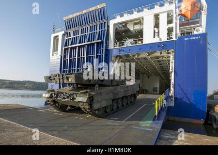 Entladen von Deutsche Kampfpanzer Leopard 2 Der sehr hohe Bereitschaft, Joint Task Force (VJTF) vom Dänischen Roll-on-roll-off-Schiff Lade Germania durch den Hafen Umgang mit Unternehmen der Deutschen Logistik Bataillons 161 im Hafen von Fredrikstad in Norwegen. NATO-Übung Trident Punkt in Norwegen, Fredrikstad am 11.10.2018. Stockfoto