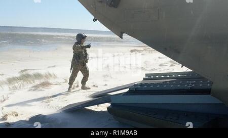 Eine CH-47 Chinook crewmember von Unternehmen B der New York Army National Guard, 3.BATAILLON, 126 Luftfahrt unterstützt mit dem Abladen der Rettungskräfte sowie Fahrzeuge, die am 13. Oktober in der Nähe von Alligator Point, eine Barriere Insel weg von Apalachicola Bay, Florida infolge der Auswirkungen des Hurrikans Michael. Der New York Army National Guard Besatzungen bereitgestellt 11 Personal und zwei Flugzeuge 1. des Florida Wachbataillon, 111 Aviation Task Force zu unterstützen. Besatzungen flogen für drei Tage, Transport 32, 240 Pfund der Ladung vor der Rückkehr zu ihren Flugbetrieb in Rochester, New York, Oktober 17. Stockfoto