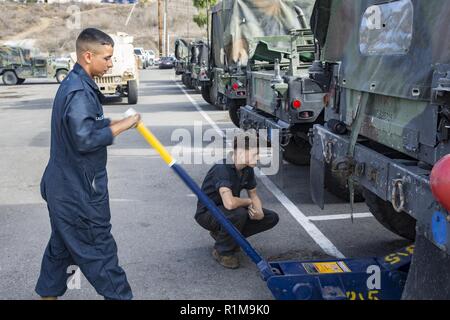 Us Marine Corps Lance Cpl. Cruz Rosales (links), und Cpl. Ashton Tillery, Automotive Wartung Techniker mit 3Rd Battalion, 5th Marine Regiment. 1St Marine Division, mit einem hydraulischen Wagenheber an der San Mateo Bereich motor Pool zu einer M 1152 High Mobility Multipurpose Radfahrzeug (HMMWV/Humvee) heben, Marine Corps Base Camp Pendleton, Kalifornien, Okt. 22, 2018. Die Humvees wurden durch routinemäßige Wartungsverfahren, um sicherzustellen, dass die Fahrzeuge für den täglichen Betrieb gelöscht wurden. Stockfoto