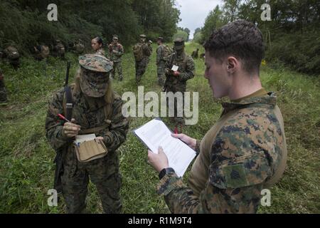 Sgt. Xavier S. Schinken, ein Motor transport Dispatcher mit S-4, zentrale Bataillon, Marine Reserve, liest eine Situation zu einer Naval Reserve Officer Training Corps Midshipmen von der Tulane University, während kleine Einheit Führung Auswertungen an Hopper Park, in Baton Rouge, La., 20. Oktober 2018. Marines aus MARFORRES, in New Orleans, unterstützt in der SULEs zu Erfahrung und Einsicht für midshipman zur Verfügung stellen, um sie besser für die Officer Candidate School und für Ihre zukünftige militärische Karriere vorzubereiten. Stockfoto