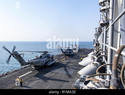 Arabische Meer (Okt. 2010) 21, 2018) CH-53E Super Stallion Hubschrauber, an der "Elche" der Marine Medium Tiltrotor Squadron (VMM) 166 (verstärkt), Vorbereitung für den Start von der Flight Deck von Wasp-Klasse amphibisches Schiff USS Essex (LL 2), die während einer planmäßigen Einsatz von Essex Amphibious Ready Gruppe und 13 Marine Expeditionary Unit. USS Essex ist eine flexible und hartnäckige Navy-Marine Corps Team in die USA 5 Flotte Bereich der Maßnahme zur Unterstützung der Marine im Einsatz für die Stabilität und Sicherheit in der Region zu gewährleisten und verbindet das Mittelmeer und die P Stockfoto