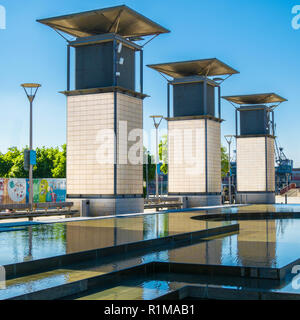 3 vent Wellen für eine Tiefgarage in einem Wasserspiel in Millennium Square vor blauem Himmel in der Stadt Bristol UK wider Stockfoto