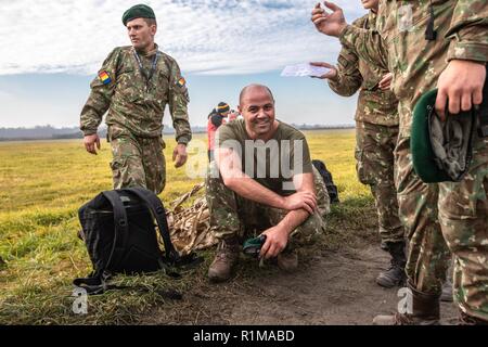 Ein rumänischer Soldat mit Kampf der Gruppe Polen rumänische Air Defence" Schwarz Fledermäuse," nimmt eine Verschnaufpause während der Polnischen "taktischen Loop" Einheitliche Manöver Wettbewerb, Okt. 20, in Rajgród, Polen. Wurde die Veranstaltung von der Shooting Association trzelec" der sozialen und pädagogischen Organisation von Grajewo, Polen. Der Wettbewerb wurde in Form eines Teams ruck März über 21 km durchgeführt, während die 22 kg pro Mitglied, in kürzester Zeit möglich. Entlang der März waren sechs, zeitlich begrenzte Kontrollpunkte Aptitude Tests des Teams in Treffsicherheit auf AK-47 und AR-15 Gewehre, Genauigkeit in Werfen einer Gre Stockfoto