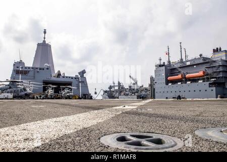 Mittelmeer (Okt. 2010) 21, 2018) Der San Antonio-Klasse amphibious Transport dock Schiff USS Anchorage LPD (23), Links, führt eine vertikale Auffüllung-auf-See mit Trockenmassengut und Munition ship USNS Medgar Evers (T-AKE-13) im Mittelmeer, Okt. 21, 2018. Anchorage und schiffte sich 13 Marine Expeditionary Unit werden in den USA 6 Flotte Bereich arbeiten wie eine Krise Response Force zur Unterstützung der regionalen Partner sowie bereitgestellt die nationale Sicherheit der USA Interessen in Europa und in Afrika zu fördern. Stockfoto