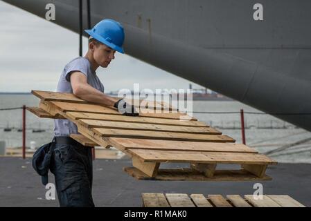 NORFOLK, Virginia (Okt. 2010) 16, 2018) der Luftfahrt Bootsmann Mate (Handling) Airman Josafat Alvarez, von Stockton, Kalifornien, Stacks eine Palette an Bord der Flugzeugträger USS George H.W. Bush (CVN 77). Das Schiff ist im Hafen in Norfolk, Virginia, die Durchführung von routinemäßigen Übungen Träger bereit zu halten. Stockfoto