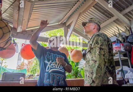 ROTA, Commonwealth der Nördlichen Marianen (Okt. 2010) 22, 2018) Builder 3. Klasse William Mathis, zugeordnet zu den Marine Mobile Konstruktion Bataillon (NMCB) (1), Trennung Guam, von Ragland, Ala, spricht mit einem Hausbesitzer während einer Tour der rekonstruierten Dächer auf Häuser, die während der Typhoon Mangkhut beschädigt wurden. NMCB 1, loslösung Guam, Commander, Task Force 75 zugeordnet, ist die Korrelation mit der Defense Security Cooperation Agency, des Commonwealth setzt sich für Wiederaufnahme Bemühungen, Cnmi und der Federal Emergency Management Agency beim Wiederaufbau der Dächer für Wohnungen bei Katastrophenhilfemaßnahmen i Stockfoto