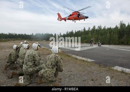 BANGOR, Washington (Okt. 23, 2018) Segler aus lokalen ballistischer Flugkörper und Raketen-U-Boote Praxis mit einem rescue Hoist von US Coast Guard MH-65 Dolphin Helikopter geführte, Coast Guard Air Station Port Angeles zugewiesen, während der medizinischen Evakuierung (Medevac) Bohrer Ausbildung bei Naval Base Kitsap-Bangor. Stockfoto