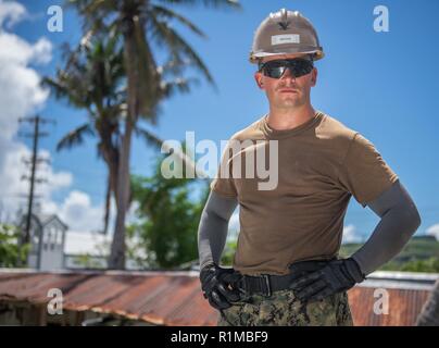 ROTA, Commonwealth der Nördlichen Marianen (Okt. 2010) 22, 2018) Builder 3. Klasse William Mathis, zugeordnet zu den Marine Mobile Konstruktion Bataillon (NMCB) (1), Trennung Guam, von Ragland, Ala, beobachtet als Matrosen zu NMCB1 zugeordnet, das Dach eines Hauses, die während Taifun Mangkhut beschädigt wurden, zu rekonstruieren. NMCB 1, loslösung Guam, Commander, Task Force 75 zugeordnet, ist die Korrelation mit der Defense Security Cooperation Agency, des Commonwealth setzt sich für Wiederaufnahme Bemühungen, Cnmi und der Federal Emergency Management Agency beim Wiederaufbau der Dächer für Wohnungen bei Katastrophenhilfemaßnahmen in Ro Stockfoto