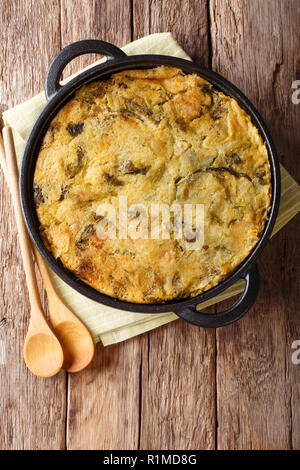 Gesunde Ernährung Englisch Lebensmittel Bubble & Squeak aus gebackenem Kartoffelpüree mit Rotkohl und Rosenkohl in einer Pfanne auf dem Tisch. Vertikale Ansicht von oben her Stockfoto