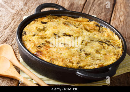 Englisches Essen Bubble & Squeak aus gebackenem Kartoffelpüree mit Rotkohl und Rosenkohl close-up in einer Pfanne auf dem Tisch. Horizontale Stockfoto