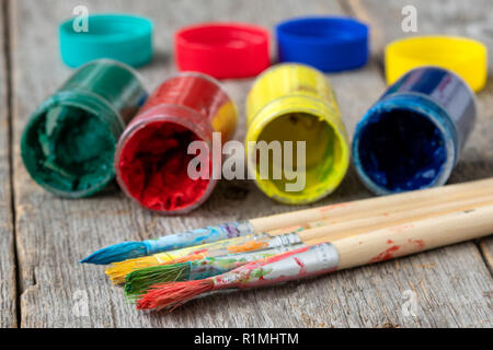 Pinsel und Gläser mit trockenen Gouache auf Holz- Hintergrund Stockfoto