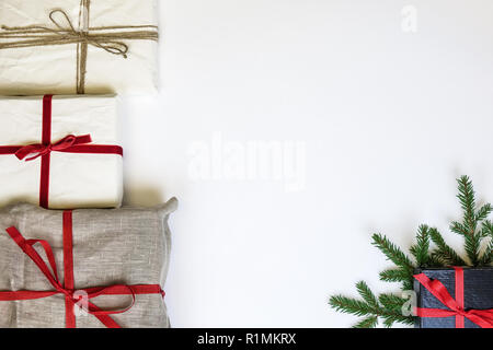 Weihnachten Geschenk Boxen auf weißem Hintergrund. Leinwand Leinwand und organische weiße Wiederverwendung/Recycling Verpackung Papier. Red Ribbon und Leinen string. Tanne t Stockfoto