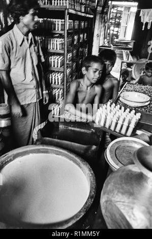 80/33 Kind Arbeiter in der Fabrik, die Sauger für Babyflaschen, Old Dhaka 1980 Stockfoto