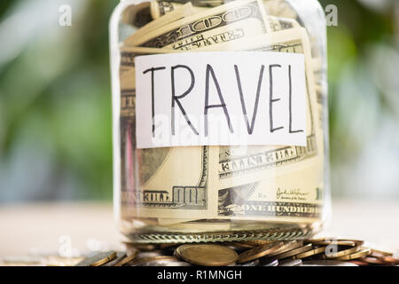 Stapel von Münzen, Glas Glas mit Dollar Banknoten und Inschrift Reisen Stockfoto