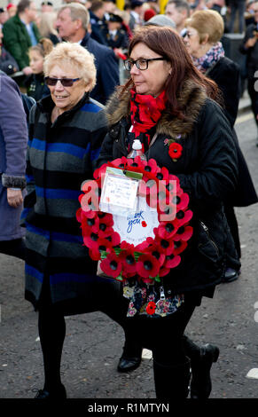 London, England, Großbritannien - 11 November 2018. Lady Teilnehmer tragen einen Kranz von Mohn in der Erinnerung Tag der Feierlichkeiten zu Fuß von Admiralty Arch in Horse Guards Parade während der Tag der Erinnerung feiern das hundertjährige Der Armistice Day 1918 zu Ehren. (Foto © Michael Cole) Stockfoto