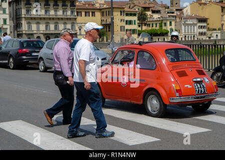 Red outdoor Modell im Verkehr mit Senioren Männer Wachen in der Stadt. Fiat 500 letzten Jahrhunderts Oldtimer. 1950 1960 1970 1980 1990 Toskana Italien Europ Stockfoto