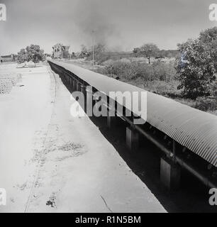 1950 s, historischen, der Abbau von Uran in Afrika, Bild zeigt die über dem Boden Tunnel mit Abdeckung verwendet das abgebaute Rohstoff Mineralien von der Grube zu transportieren. Stockfoto