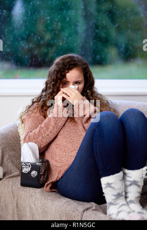 Frau mit Gewebe ihre Nase weht Stockfoto