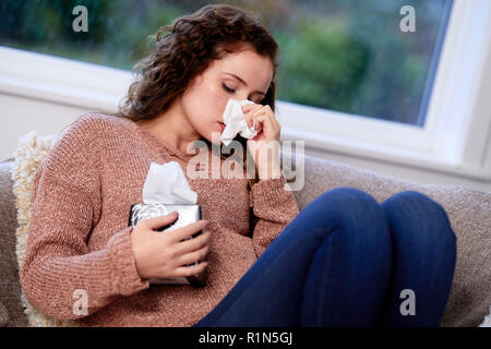 Frau mit Gewebe ihre Nase weht Stockfoto