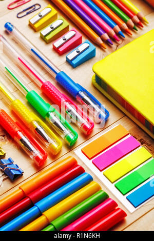 Gruppe von Schulmaterial und Notebooks auf hölzernen Tisch Stockfoto