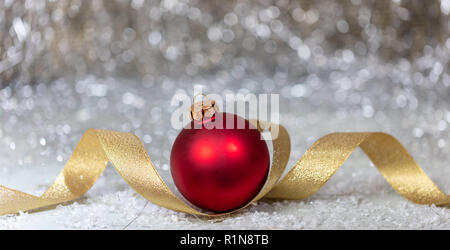 Weihnachten rote Kugel, goldene Schleife und Schnee, abstrakte Bokeh leuchtet Hintergründe, Banner Stockfoto
