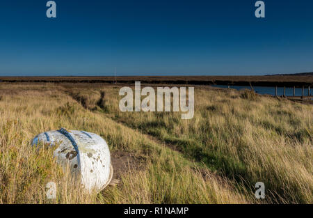 Ein umgedrehter Ruderboot und Weg oder Anschluss über das Wattenmeer und Christian gras Sümpfe an morston Hafen oder Creek in Norfolk an der Küste. Stockfoto