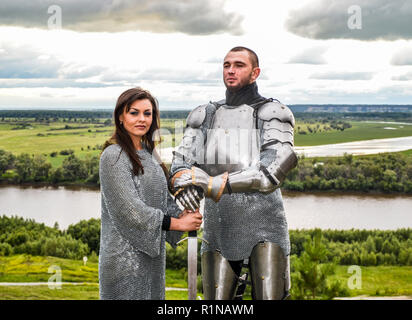 Ritter mit seiner Frau in Rüstung und Chain Mail. Ritterlichen Rüstung und Waffe. Semi-antik Foto. Stockfoto