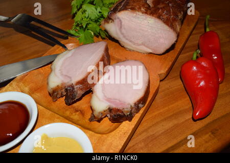 Kassler auf Holz rustikale Platte. Es ist oft mit Sauerkraut und Kartoffelpüree serviert. Vollständig ausgehärtet und geräuchertem Schweinefilet Koteletts auf einer hölzernen Fach gekocht Stockfoto