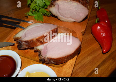 Kassler auf Holz rustikale Platte. Es ist oft mit Sauerkraut und Kartoffelpüree serviert. Vollständig ausgehärtet und geräuchertem Schweinefilet Koteletts auf einer hölzernen Fach gekocht Stockfoto